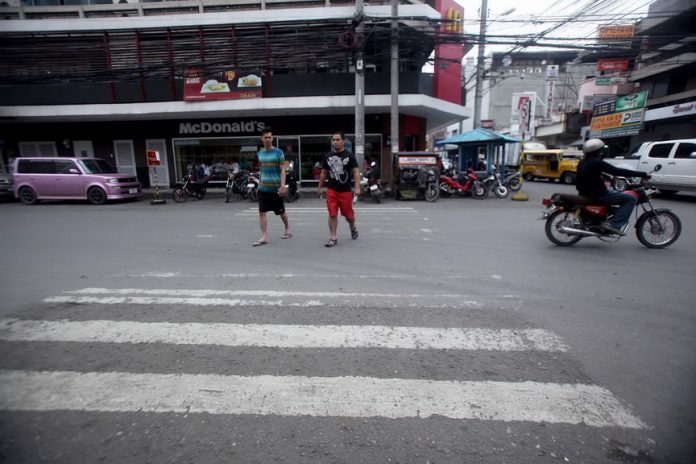 WHERE’S THE PEDESTRIAN? Pedestrians cross a street in Davao City using an almost unrecognizable pedestrian lane that need to be repainted. Mayor Sara Duterte-Carpio has ordered traffic enforcers to strictly implement the anti-jaywalking ordinance to ensure road safety and prevent congestion in the city streets starting December 1. Lean Daval Jr.