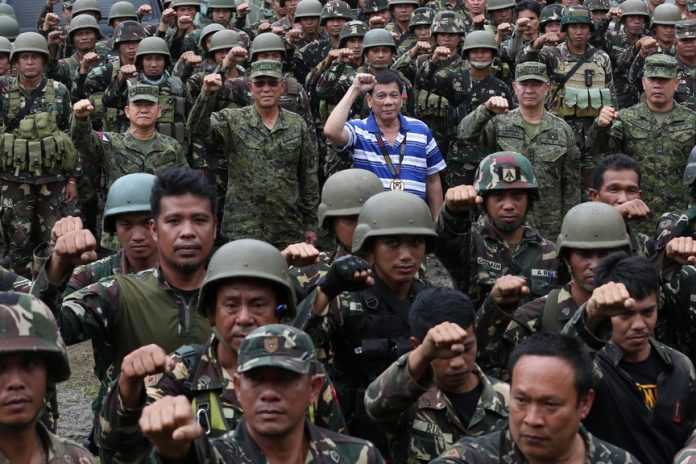 President Rodrigo Road Duterte poses with members of the military during his visit at the 103rd Brigade in Lumbayanague town, Lanao del Sur on November 30,2016. TOTO LOZANO/Presidential Photo