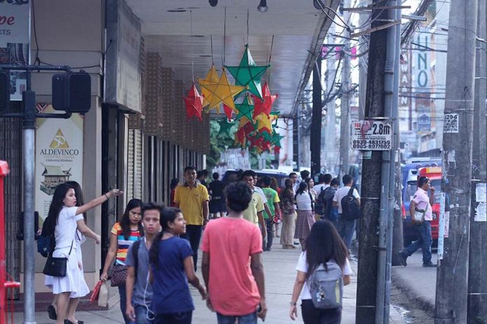 SEASON GREETINGS. Dabawenyos walk through the sidewalk near Aldevinco Shopping Center which is now decorated with colorful Christmas lanterns. The place is a favorite shopping destination for souvenir items of foreign and domestic tourists of the city which are expected to flock this yuletide season. LEAN DAVAL JR.