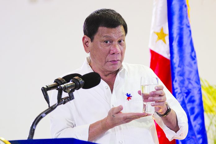 PUTTING THE MESSAGE ACROSS. President Rodrigo Duterte holds a glass of water to stress a point while answering questions during a news conference upon his arrival from Auckland, New Zealand and from the participation to the Asia-Pacific Economic Cooperation (APEC) leaders' meeting in Lima, Peru at the Davao International Airport in Davao City last week. Duterte pushes through with his scheduled visit to Lanao del Sur today despite an IED explosion that injured seven members of the Presidential Security Group and two other soldiers yesterday. LEAN DAVAL JR.