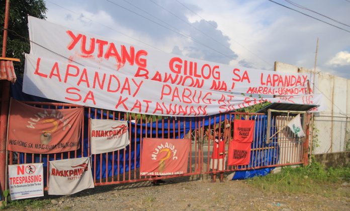 MARBAI members deliver their message along the highway in Madaum, Tagum City. Lapanday Foods Corporation denied involvement in the December 12 shooting incident in the banana plantation that injured seven farmworkers. MindaNews photo by Gregorio Bueno