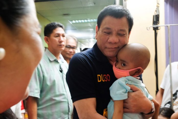 PRESIDENTIAL COMFORT. President Rodrigo R. Duterte embraces a cancer-stricken child during his visit at the Southern Philippines Medical Center's Children's Cancer and Blood Diseases Unit in Davao City on Christmas eve. KING RODRIGUEZ/Presidential Photo