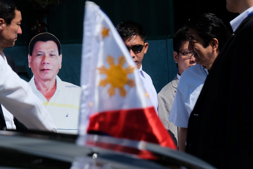 Japan Prime Minister Shinzo Abe chuckles upon seeing the standee of President Rodrigo Roa Duterte outside his residence at Doña Luisa Village in Davao City on January 13, 2017. RENE LUMAWAG/Presidential Photo