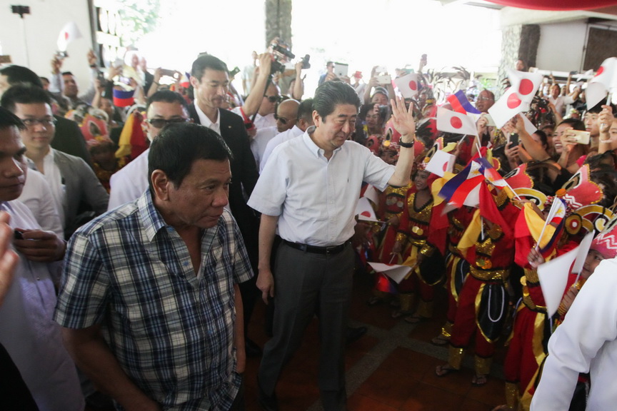 Prime Minister Shinzo Abe waves to cultural dancers as President Rodrigo Roa Duterte walks beside him upon their arrival at the Waterfront Hotel where they attended several ceremonies as part of the last day of the Prime Minister's official visit to the Philippines on January 13, 2017. SIMEON CELI JR./Presidential Photo