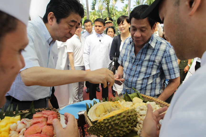 Japan Prime Minister Shinzo Abe eats durian fruit with President Rodrigo Roa Duterte after attending various events at the Waterfront Hotel in Davao City on January 13, 2017. SIMEON CELI JR./Presidential Photo