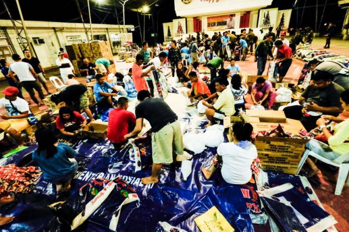 RELIEF GOODS. Hundreds of volunteers from the provincial government of Davao Oriental, the military, police and private support groups gathered at the provincial capitol covered court starting Monday evening to help pack relief goods intended for the victims of calamity in the area. (Eden Jhan Licayan/PIO DavOr)