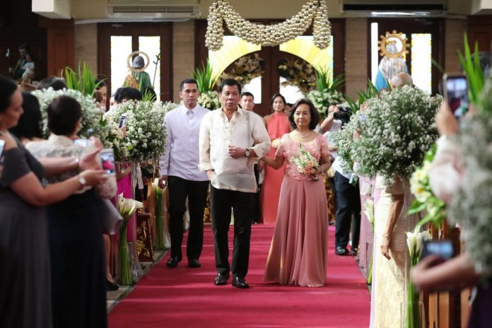 TAKES TWO TO TANGO. President Rodrigo Roa Duterte and former President, now incumbent Pampanga 2nd District Representative Gloria Macapagal Arroyo walks on the center aisle of Sanctuario de San Jose in Mandaluyong City on Sunday as principal sponsors during the wedding ceremony of Gonzalito Nicolo Duque and Kristel Ann-Marie Bejar. ALBERT ALCAIN/ Presidential Photo