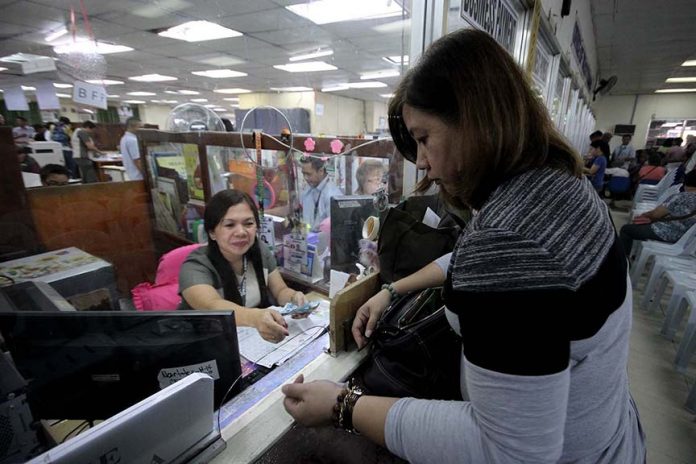 PERMIT RENEWAL. A business owner pays her permit fee at the Office of the Treasurer at Sangguniang Panlungsod building in Davao City during the second day of business permit renewal yesterday. LEAN DAVAL JR.