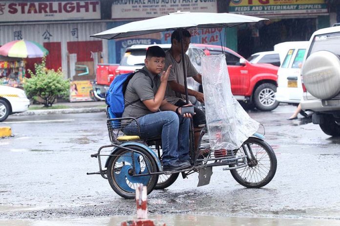 WHAT RAIN BRINGS. Trisikad drivers like this one takes advantage of the rain to earn more as demand for trisikad ride increased yesterday especially near the universities and colleges around Davao City. Lean Daval Jr.