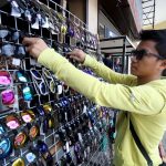 WHATEVER IT TAKES. A sidewalk vendor ignores the heavy downpour as he continues to display knock off eyewear he sells along San Pedro Street in Davao City yesterday. LEAN DAVAL JR.