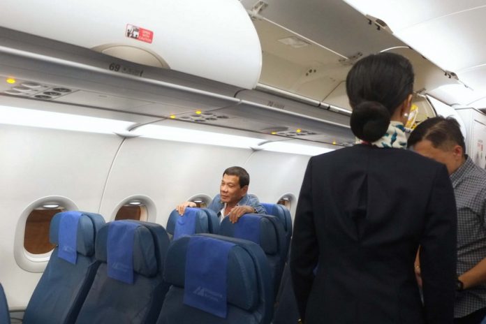 PASSENGER RODY. President Rodrigo Duterte is ushered to his seat as he takes a commercial flight from Manila to Davao City on Thursday evening. Here, the President greets the other passengers before taking a seat at the economy class section of the plane. TOTO LOZANO/ Presidential Photo