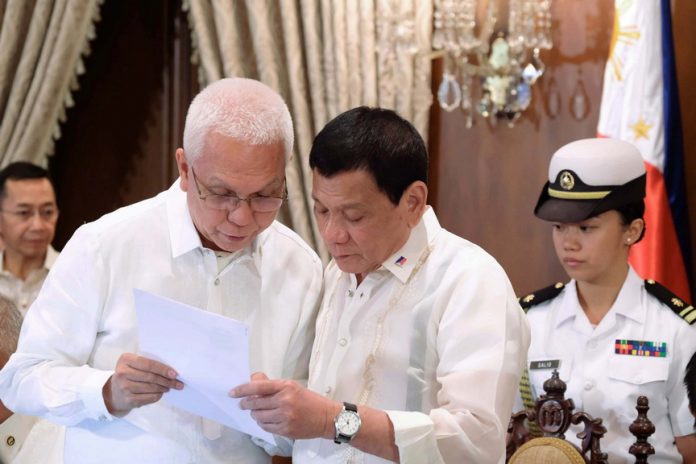 ORDER OF BUSINESS. President Rodrigo Duterte is shown the agenda of the 11th Cabinet meeting by Cabinet Secretary Leoncio Evasco Jr. at the State Dining Room of Malacañan Palace on Monday evening. ACE MORANDANTE/Presidential Photo