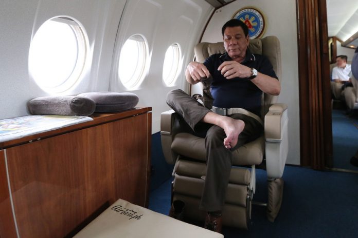 IN THE INTERIM. President Rodrigo Duterte takes time to relax while on board a government plane to Davao City following his visit to Tacloban City and Lapu-Lapu City in Cebu on Wednesday afternoon. KING RODRIGUEZ/Presidential Photo