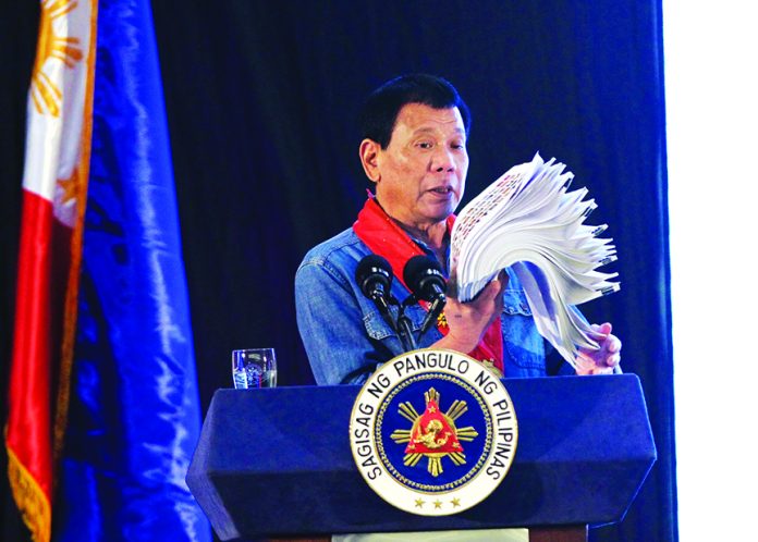 UNHOLY MIX. President Rodrigo Duterte shows his list of government officials, members of judiciary and police officers involved in illegal drug trade during the 38th Philippine Association of Water Districts National Convention at SMX Convention Center in Lanang, Davao City yesterday. LEAN DAVAL JR