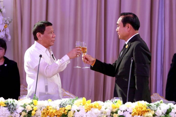 HONORING THE OCCASION. President Rodrigo Duterte and Thai Prime Minister General Prayut Chan-o-cha hold a toast during the state dinner at the Government House in Bangkok, Thailand on Wednesday night. RICHARD MADELO/Presidential Photo