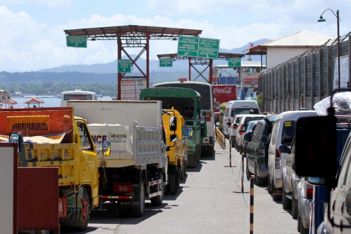 PILE-UP. Vehicles owned by beach-goers waiting for their turn to board a Roll-on/Roll-off vessel to the Island Garden City of Samal (IGaCoS) form a queue stretching out to two kilometers long in Sasa, Davao City on Saturday. Beach lovers flocked to IGaCoS for summer break outing and Holy Week celebration. LEAN DAVAL JR.