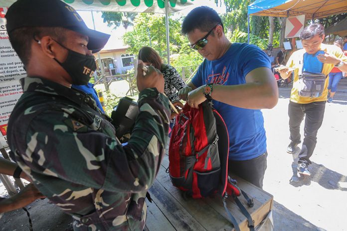 A member of Task Force Davao performs a search on a bus passenger's backpack at a checkpoint in Lasang, Davao City on Wednesday (24 May 2014) as the city tightens security following the declaration of martial law for the whole of Mindanao by President Rodrigo Duterte. MindaNews photo by Manman Dejeto