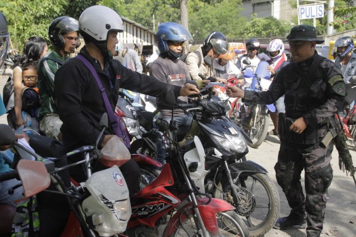 Motorists stop for inspection at the police checkpoint in Barangay Suarez in Iligan City on Tuesday, 30 May 2017, a week after Mindanao was placed under martial law in response to the clashes in Marawi City between government forces and the Maute group. MindaNews photo by H. Marcos C. Mordeno