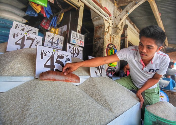PRIMING UP. A worker of a rice dealership establishment fixes his display of different varieties of commercial rice at Agdao Public Market in Davao City on Wednesday. Prices of commercial rice went up in the city’s public markets as an effect of the National Food Authority’s announcement that their buffer stock has reached a critical low. LEAN DAVAL JR.