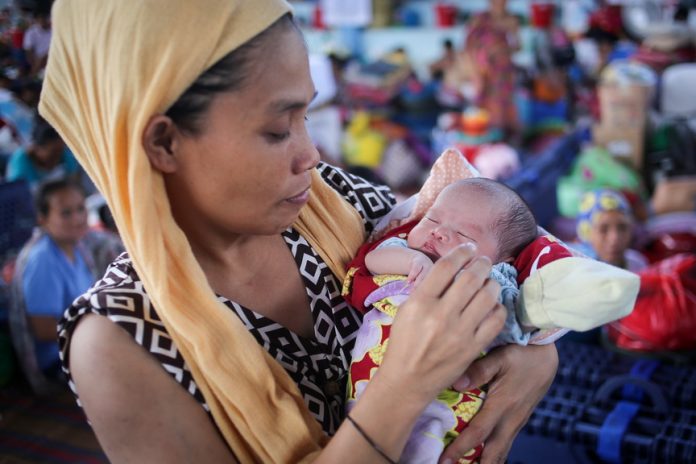 Anisa Bongcarawan, 39, holds her infant daughter Asmira at an evacuation center for Marawi City residents in Brgy Maria Cristina, Iligan City on Saturday, June 24, 2017. Asmira, her 8th child, was born on Independence Day, June 12, 2017. MindaNews photo by Manman Dejeto