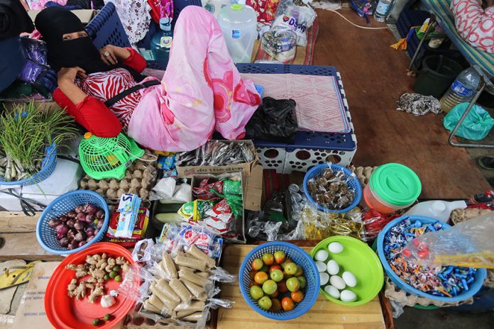 Norania Bangon attends her small sari-sari store inside the evacuation camp. MindaNews photo by MANMAN DEJETO