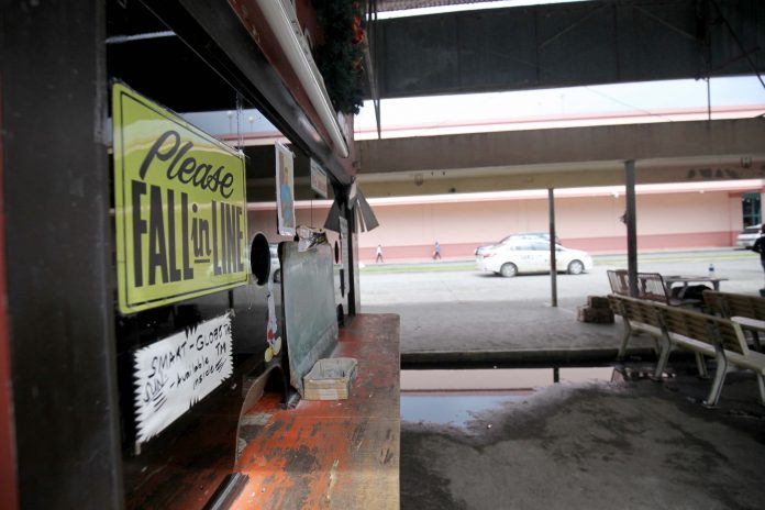 FIRST COME, FIRST SERVED. A ‘Please Fall in Line’ sign is seen in front of a usually very busy cashier’s booth of VP northbound van satellite terminal days after the Land Transportation Franchising and Regulatory Board (LTFRB) 11 issued a suspension order to northbound passenger vans due to a deadly road mishap in Bunawan District on Wednesday. LEAN DAVAL JR.