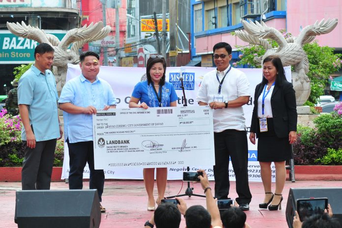 The City Government of Davao receives the P100,000.00 check for winning the Gawad Kalasag Award in the Highly Urbanized City Category, Monday morning.