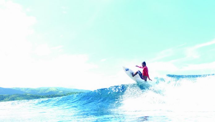 Surfer Martin Taniegra flies up the wave. Photo by Michael Eijansantos.