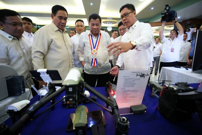 UPDATING.PresidentDuterte is joined by National Security Adviser HermogenesEsperon Jr. as he is being briefed on one of the technologies used by the National Security Council during the council's 67th anniversary celebration at the Tejeros Hall of Camp Emilio Aguinaldo in Quezon City on Wednesday. PRESIDENTIAL PHOTO