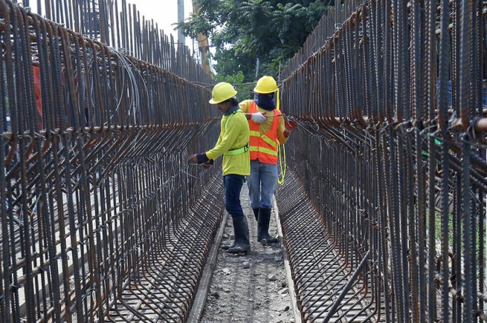 IRON WORKS. Workers tie round bars with a wire for a girder which will be used in the ongoing rehabilitation and expansion of Ma-a Bridge along Carlos P. Garcia Highway in Davao City on Tuesday. LEAN DAVAL JR.