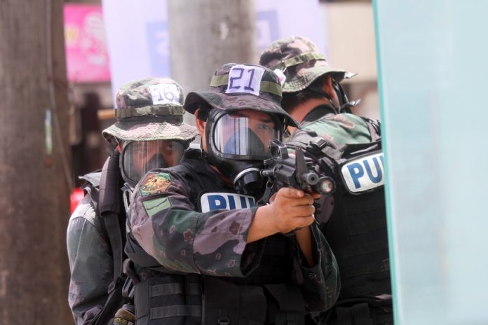 KEEPING IN SHAPE. Police officers from the Davao City Police Office (DCPO) in full battle gear simulate an urban assault along Rizal Street in Davao City as part of the 15-day Special Weapons and Tactics training under the Davao City Police Office on Tuesday. LEAN DAVAL JR.