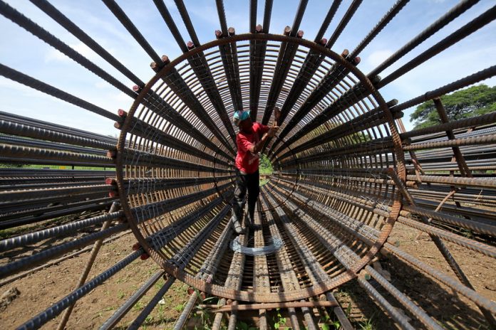 HOW IT IS DONE. An ironworker ties the steel bar with a wire to form a reinforcement cage which will be used in the ongoing rehabilitation of Ma-a Bridge along Carlos P. Garcia Highway in Davao City on Monday. LEAN DAVAL. JR.