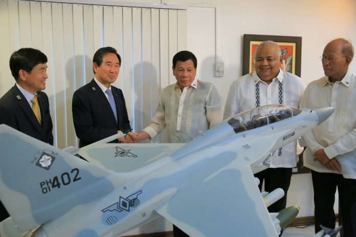 SOUTH KOREAN-MANUFACTURED.President Duterte takes time to admire the FA-50 model given as token by Korean Aerospace Industries (KAI) President and CEO Sung-Yong Ha who paid a courtesy call on the President at the Clark Air Base in Pampanga on Tuesday. Also in the photo are Executive Secretary Salvador Medialdea and Defense Secretary DelfinLorenzana. PRESIDENTIAL PHOTO