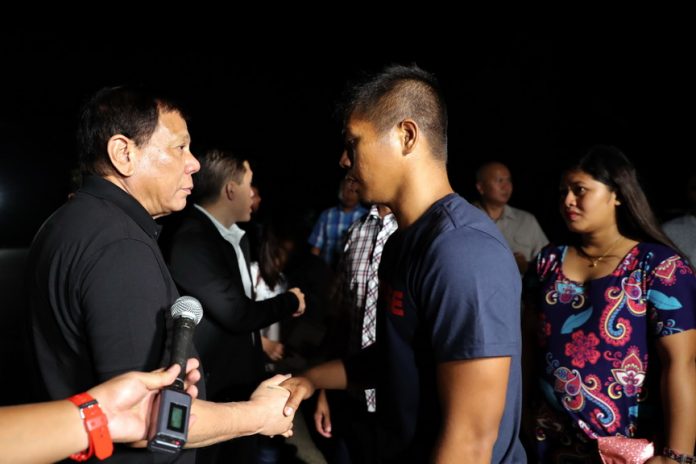 BACK TO UNIT. President Duterte personally checks the condition of Police Officer Alfredo Basabica Jr. after the latter was presented to the President at the Tactical Operations Group (TOG)-11 Headquarters in Davao City on Sunday. PO1 Basabica, a member of 2nd Platoon of the Davao Oriental Provincial Public Safety Command in Aliwagwag PPSC Patrol Base in Cateel, Davao Oriental, was taken by members of the New People’s Army while on board a passenger bus on his way home along Kilometer 26 of Barangay Panansalan in Compostela town, Compostela Valley Province last July 11. ROBINSON NIÑAL/ PRESIDENTIAL PHOTO