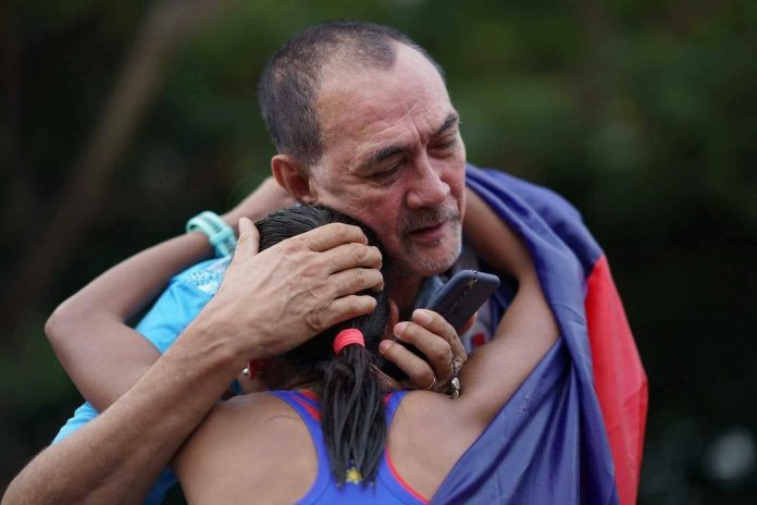 EMOTIONAL. The Philippines’ Mary Joy Tabal gets a warm embrace from PSC Commissioner Ramon Fernandez after she gave the Phiippines its first gold medal in the 29th Southeast Asian Games in Kuala Lumpur. Tabal silenced all her critics and had Fernandez to thank for following her golden run as the sports leader from Cebu is her staunch supporter. PSC photo