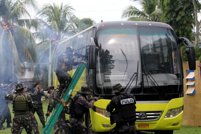 WORST CASE SCENARIO. Members of Davao City Police Office (DCPO) Special Weapons and Tactics (SWAT) unit class ‘Dalubhasa’ conduct a final rehearsal of a rescue operation simulation against ‘terrorists’ inside a passenger bus at Camp Domingo Leonor Sr. on Wednesday. Davao City Mayor Sara Duterte-Carpio will be the guest of honor when 45 police officers will graduate today from a 45-day SWAT training. LEAN DAVAL JR.