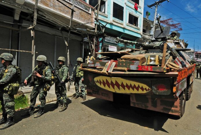 Philippine Marines backed by a V300 armored vehicle cross Mapandi Bridge in Marawi City on Wednesday (Aug. 30, 2017), 100 days since the Islamic State-inspired Maute group started a siege that has made the city a ghost town. Government troops recaptured the bridge from the militants late last month. MindaNews photo by FROILAN GALLARDO