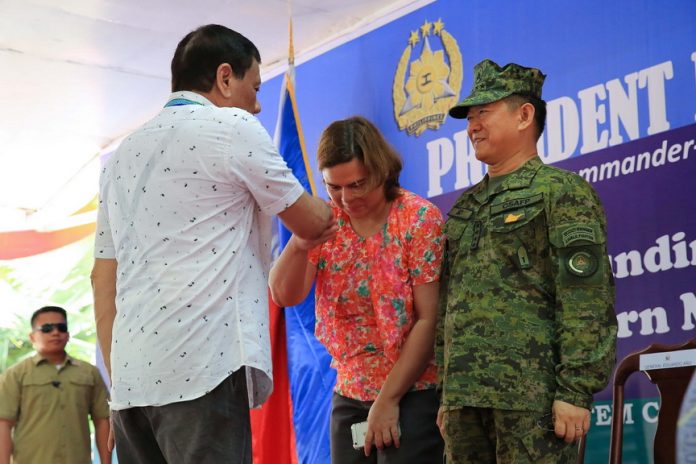 SHOW OF RESPECT. President Duterte extends his hand to Davao City Mayor Sara Duterte-Carpio who showed a gesture of respect to her father during the Eastern Mindanao Command (EastMinCom) 11th Founding Anniversary celebration at the Naval Station Felix Apolinario in Panacan in Davao City on Friday afternoon. Also in the photo is Armed Forces of the Philippines Chief of Staff General Eduardo Año. ALBERT ALCAIN/PRESIDENTIAL PHOTO