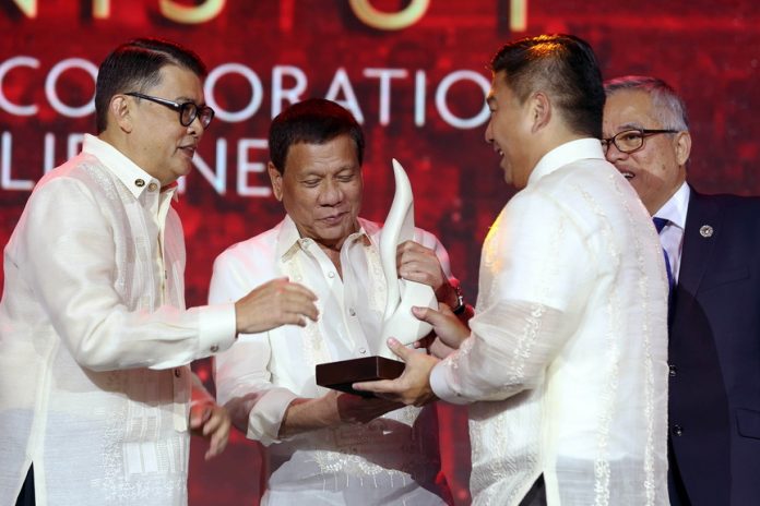 WORTHY OF REPLICATION. President Duterte hands over the award to Udenna Corporation founder Dennis Uy who is merited as the lone Young Entrepreneur of the Year awardee during the Association of Southeast Asian Nations (ASEAN) Business Awards at the Solaire Resort and Casino Grand Ballroom in Parañaque City on Wednesday night. The President, who led the awarding to the 30 awardees, is assisted by Trade and Industry Secretary Ramon Lopez, Presidential Consultant for Entrepreneurship Joey Concepcion, and Philippine ASEAN Business Advisory Council Council Members Tessie Sy-Coson and George Barcelon. RICHARD MADELO/PRESIDENTIAL PHOTO