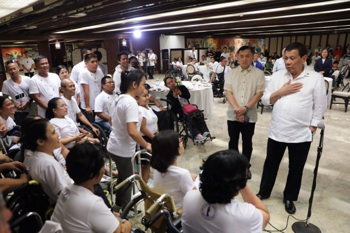 WITH THE HANDICAP. President Duterte shares a light moment with members of the Our Lady of Victory Training Center Inc. during a dinner hosted by the President at the Malacañan Palace on Wednesday evening. RICHARD MADELO/PRESIDENTIAL PHOTO