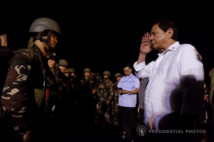 SEEING THE TROOPS OFF. President Duterte salutes to each of the troops from the 1st Infantry Battalion (1IB) who were preparing to leave at the Laguindingan Airport in Misamis Oriental on Friday evening. The 1IB were among the first units deployed in Marawi City when the battle against the terrorists broke out almost five months ago. PRESIDENTIAL PHOTO