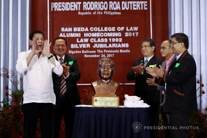 BEDAN OF THE YEAR. President Rodrigo Duterte cheers after a bust recognizing him as the 'Bedan of the Year' is presented to him during the San Beda Law Annual Alumni Homecoming at The Peninsula Manila in Makati City on Friday evening. PRESIDENTIAL PHOTO