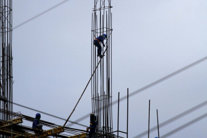 BUILDING FRENZY. An ironworker works on the metal structure of a mid-rise condominium building along J.P. Laurel Avenue in Davao City on Wednesday. Davao City’s construction boom is expected to continue its upswing trend as major real estate developers from Manila and Cebu will start their projects in the city early next year. LEAN DAVAL JR.