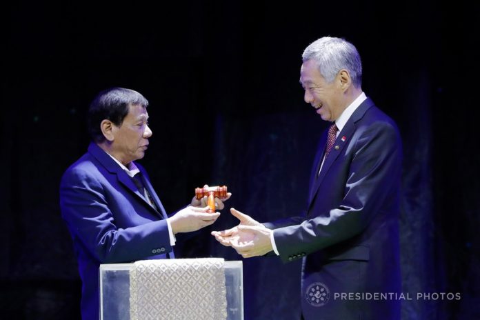 NEW CHAIR. President Rodrigo Duterte hands over the gavel to Singapore Prime Minister Lee Hsien Loong to signify the turn over the Association of Southeast Asian Nations (ASEAN) Chairmanship to the Republic of Singapore during the ceremony at the Philippine International Convention Center on Tuesday night. PRESIDENTIAL PHOTO