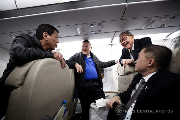 CAUCUS UP IN THE CLOUDS. President Rodrigo Duterte shares a light moment with Finance Secretary Carlos Dominguez III, Quezon City 4th District Representative Feliciano Belmonte Jr. and Special Assistant to the President Christopher Lawrence Go while on-board the Philippine Airlines chartered flight as they head back to the Philippines following a successful two-day official visit to Japan that ended on Tuesday. SIMEON CELI JR./PRESIDENTIAL PHOTO