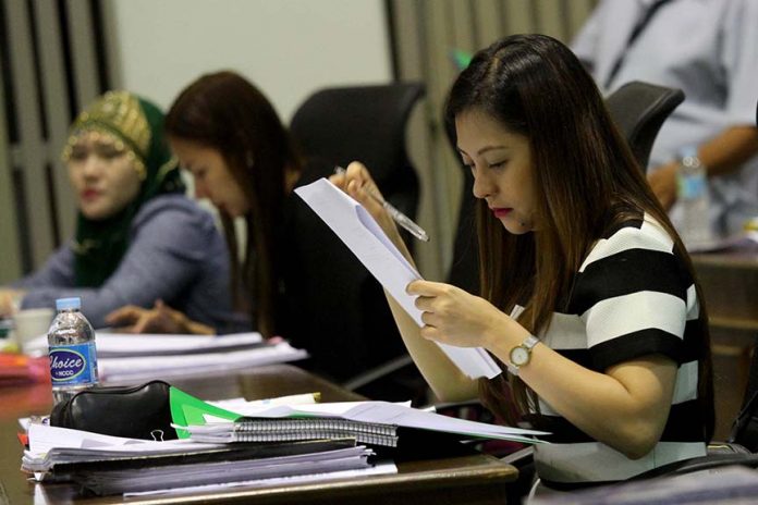 NEW TACK. Councilor April Marie Dayap examines a document during a regular session at Sangguniang Panlungsod on Tuesday. The Davao City Council is set to go paperless starting next year to lessen their paper consumption which reaches up to 50 kilograms per session or 8,000 kilograms per year. LEAN DAVAL JR.