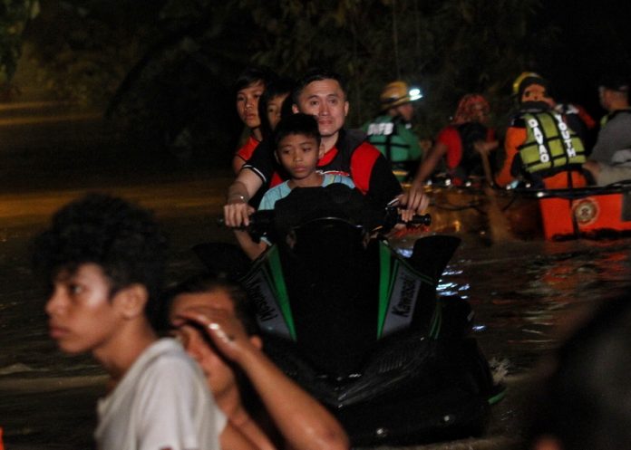 TO THE RESCUE! Assistant Secretary Christopher Lawrence “Bong” Go, special assistant to President Rodrigo Duterte, leads the rescue operation and evacuation of trapped residents in heavily-flooded Jade Valley, Davao City on Friday night. Jade Valley and some other communities near Davao River experienced flooding as the river overflowed due to heavy downpour in the city’s hinterlands spawned by tropical storm Vinta. LEAN DAVAL JR.