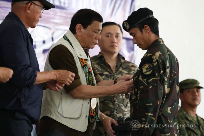 WELL-DESERVED. President Rodrigo Duterte confers the Order of Lapu-Lapu award on one of the troops who contributed to the successful liberation of Marawi City from the terrorists during his visit at Camp General Teodulfo Bautista in Barangay Bus-Bus, Jolo, Sulu on Friday. Also in the photo are Defense Secretary Delfin Lorenzana, Special Assistant to the President Christopher Lawrence Go and Philippine Army Commander Lieutenant General Rolando Bautista. RICHARD MADELO/PRESIDENTIAL PHOTO