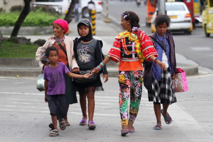 SEASON SIGHT. A group of Indigenous People from the hinterlands of Davao City roams around Davao City’s downtown area to solicit Christmas gifts from the establishments and residents on Monday. LEAN DAVAL JR.