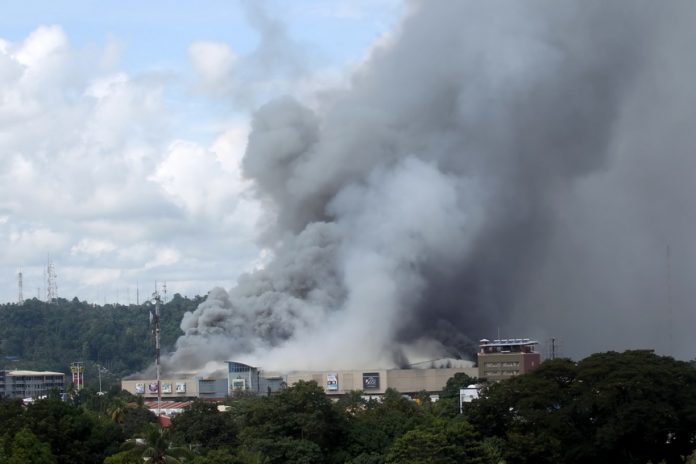 RAGING INFERNO. Dark smoke billows from NCCC mall building in Ma-a, Davao City as fire razed the shopping center on Saturday. LEAN DAVAL JR.